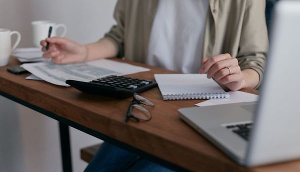 Person reviewing finances at a desk with a laptop